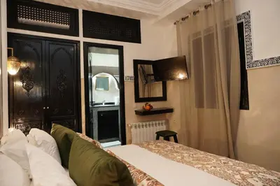 a bedroom with a bed and a window at Riad Roummana Marrakech in Marrakech