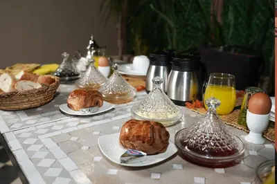 a table with eggs and croissants and food on it at Riad Roummana Marrakech in Marrakech
