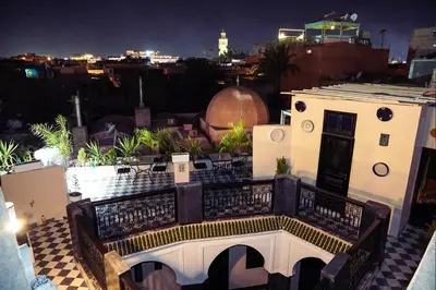 a view of a building with a balcony at night at Riad Roummana Marrakech in Marrakech