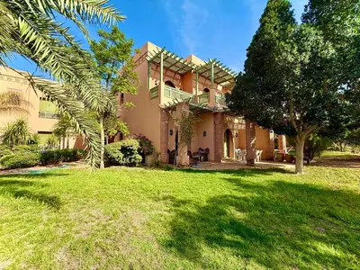 an exterior view of a house with a yard at Les Jardins de la palmeraie in Marrakech