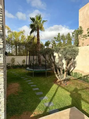 a playground in a yard with a palm tree at magnifique villa golf amelkis sans vis-à-vis in Marrakech