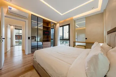 a bedroom with a large white bed and glass walls at Villa Tolède by TheCasaEdition in Marrakech