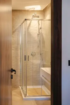 a shower with a glass door next to a sink at Appartement Uniquement Familial 2 Chambres spacieux cosy, calme in Marrakech