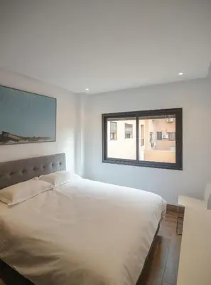 a bedroom with a white bed and a window at Appartement Uniquement Familial 2 Chambres spacieux cosy, calme in Marrakech