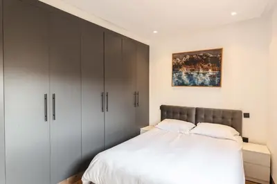 a bedroom with white cabinets and a bed at Appartement Uniquement Familial 2 Chambres spacieux cosy, calme in Marrakech
