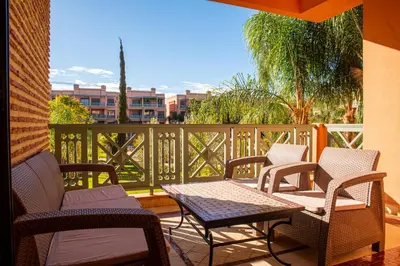 a patio with a table and chairs on a balcony at Tibouda House Deluxe Avec Piscine - Familiale in Marrakech