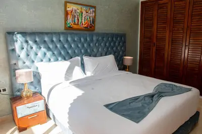 a bedroom with a large white bed with a blue headboard at Tibouda House Deluxe Avec Piscine - Familiale in Marrakech