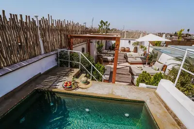 a swimming pool on the side of a house at Riad Assouel et Spa By La Siredrah in Marrakech