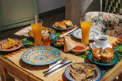 a table with plates of food and glasses of orange juice at Riad Assouel et Spa By La Siredrah in Marrakech