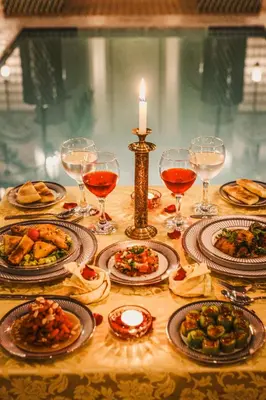 a table with plates of food and glasses of wine at Riad Assouel et Spa By La Siredrah in Marrakech