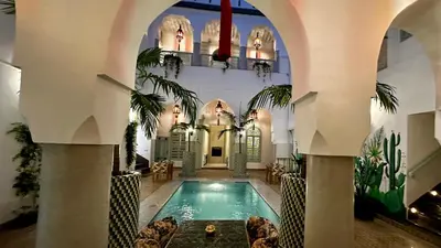 an indoor swimming pool in a building with an arcade at Riad Assouel et Spa By La Siredrah in Marrakech