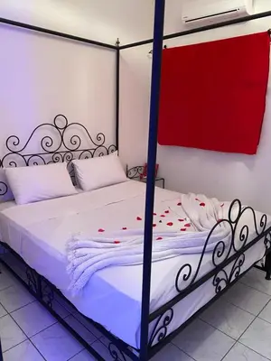 a bedroom with a four poster bed with flowers on it at Riad Ayiss piscine palmeraie in Marrakech