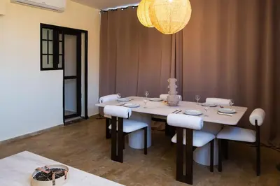 a dining room with a table with chairs and a chandelier at The Vogue – Marrakech Centre in Marrakech