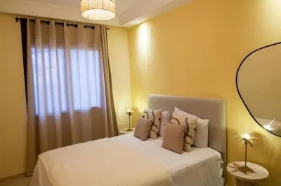 a bedroom with a white bed with a window at The Vogue – Marrakech Centre in Marrakech