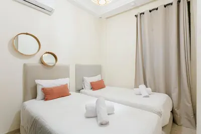 two beds in a room with two mirrors at The Vogue – Marrakech Centre in Marrakech