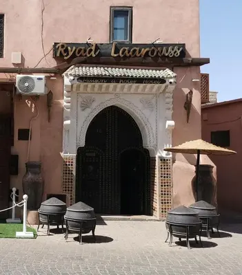 a group of tables and umbrellas in front of a building at Ryad Laârouss in Marrakech