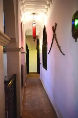 a hallway with a red light on a wall at Ryad Laârouss in Marrakech