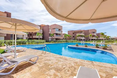 an image of a swimming pool with chairs and an umbrella at luxueux & spacieux appartement a prestigia in Marrakech