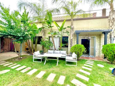a patio with a white table and chairs in a yard at Villa privée avec piscine Sans vis-à-vis, calme absolu in Marrakech