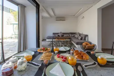 a table with breakfast foods on it in a living room at Villa privée avec piscine Sans vis-à-vis, calme absolu in Marrakech