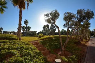 a park with palm trees and a road at Luxueux Duplex 2CH dans une magnifique résidence in Marrakech