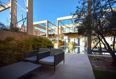 a building with two chairs and a table in front of it at Luxueux Duplex 2CH dans une magnifique résidence in Marrakech