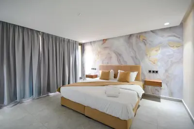 a bedroom with a large bed with a painting on the wall at Luxueux Duplex 2CH dans une magnifique résidence in Marrakech