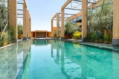 a swimming pool in front of a building at Luxueux Duplex 2CH dans une magnifique résidence in Marrakech