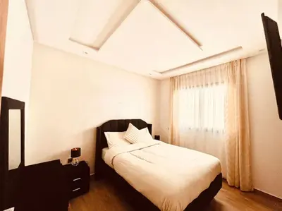 a bedroom with a bed with white sheets and a window at Menara Garden pool in Marrakech