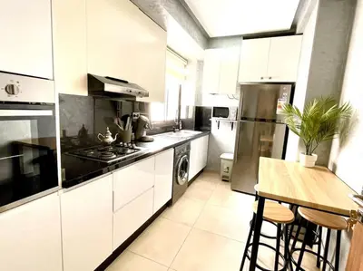 a kitchen with white cabinets and a stove top oven at Menara Garden pool in Marrakech