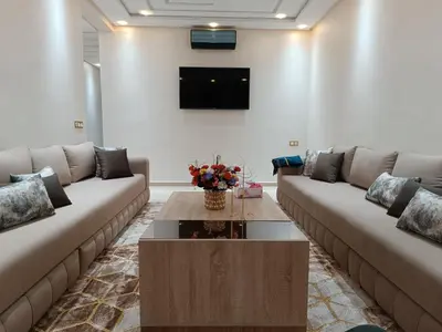 a living room with two couches and a coffee table at Chez bousfyha in Marrakech
