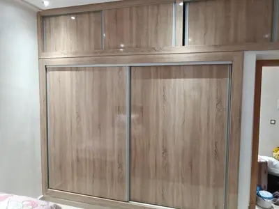 a wooden cabinet with glass doors in a room at Chez bousfyha in Marrakech