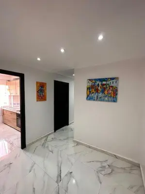 a living room with white walls and marble floors at Charmant appartement avec piscine 2chambres au cœur de Guéliz in Marrakech