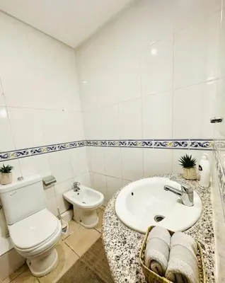 a white bathroom with a toilet and a sink at Charmant appartement avec piscine 2chambres au cœur de Guéliz in Marrakech