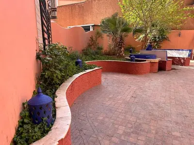 a brick walkway with a blue fire hydrant next to a building at Charmant appartement avec piscine 2chambres au cœur de Guéliz in Marrakech