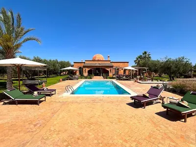 a swimming pool with lounge chairs and a house at Palais Sena in Marrakech