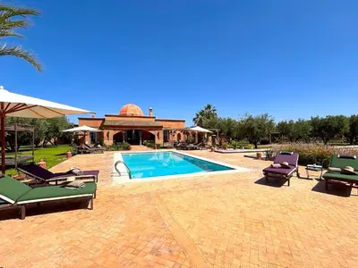 a swimming pool with lounge chairs and a house at Palais Sena in Marrakech