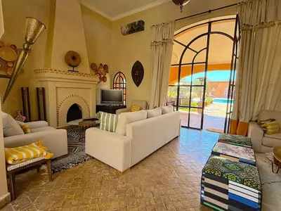 a living room with white furniture and a fireplace at Palais Sena in Marrakech