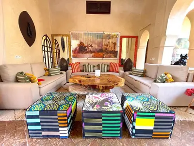 a living room with a table and two ottomans at Palais Sena in Marrakech