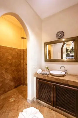 a bathroom with a sink and a shower with a mirror at Palais Sena in Marrakech