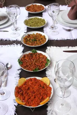 a table with plates of food and wine glasses at Riad L'Aziza in Marrakech