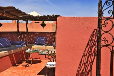 a patio with a table and chairs on a building at Riad L'Aziza in Marrakech