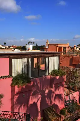 a balcony of a house with a pink wall at Riad L'Aziza in Marrakech