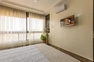 a bedroom with a large bed and a window at Appartement Raffiné au Centre in Marrakech