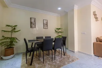 a dining room with a black table and chairs at Appartement Unique au Centre in Marrakech