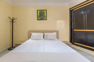 a bedroom with a large bed with white sheets at Appartement Unique au Centre in Marrakech