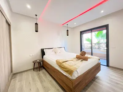 a bedroom with a bed with a teddy bear on it at Condo in marrakech with pool in Marrakech