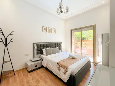 a bedroom with a large bed and a window at Condo in marrakech with pool in Marrakech