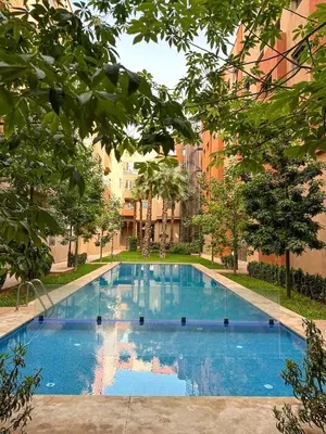 a large blue swimming pool with buildings in the background at Condo in marrakech with pool in Marrakech