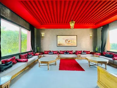 a living room with red pillows and a red ceiling at Villa Dar El Hna in Marrakech